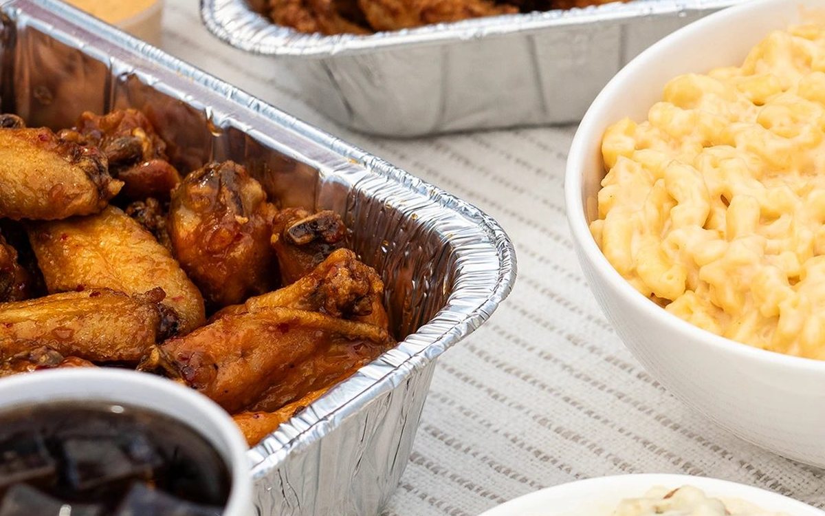Slim Chickens catering trays with tenders, wings, mac and cheese and sides